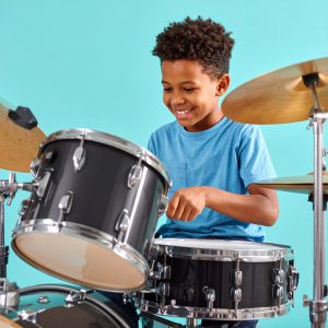 smiling elementary student taking drum lessons music lessons at our Metro Vancouver studio, serving New West, Burnaby, and Coquitlam