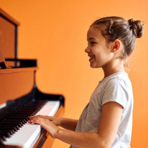 Happy elementary student at a piano lesson imusic lessons at our Metro Vancouver studio, serving New West, Burnaby, Surrey and Coquitlam