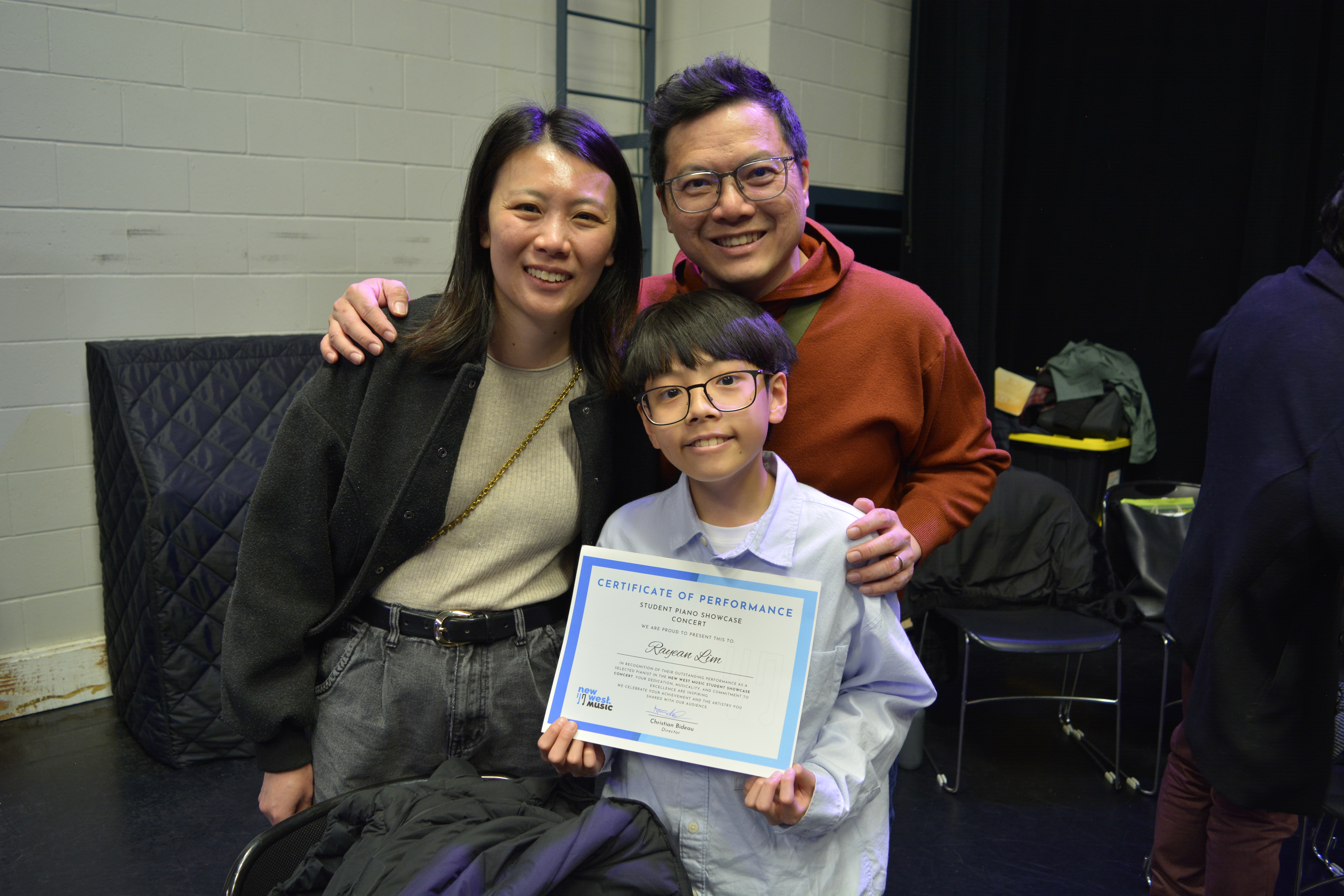 Proud parents celebrating their son’s music performance with an achievement certificate in our Metro Vancouver music program.